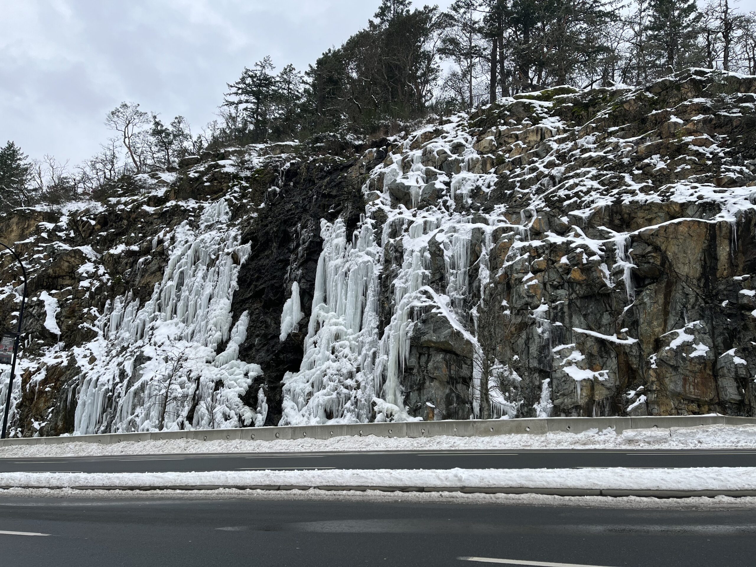 Frozen ice formations on Malahat highway rock face in winter