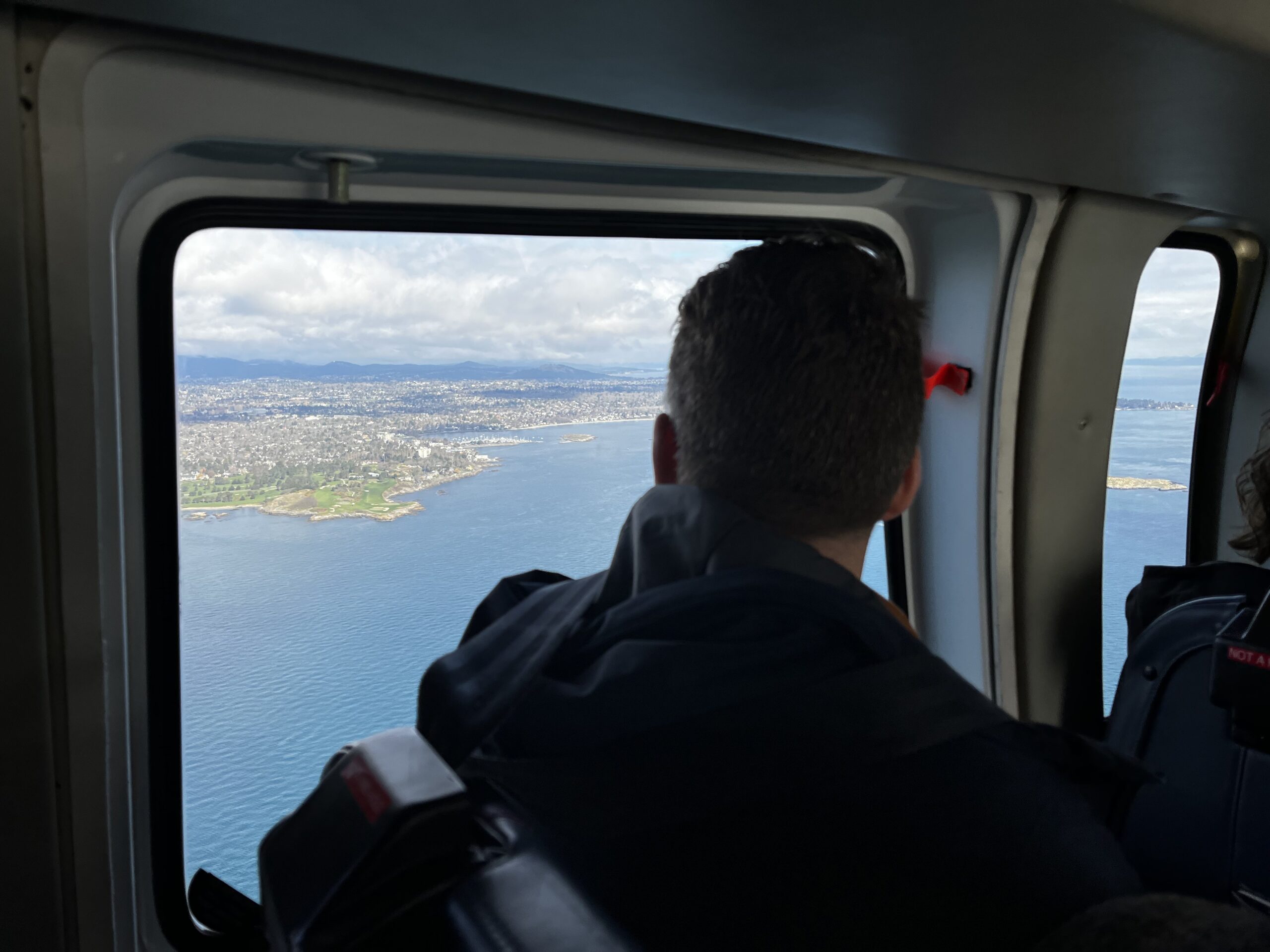 View through Helijet helicopter window approaching Victoria coastline